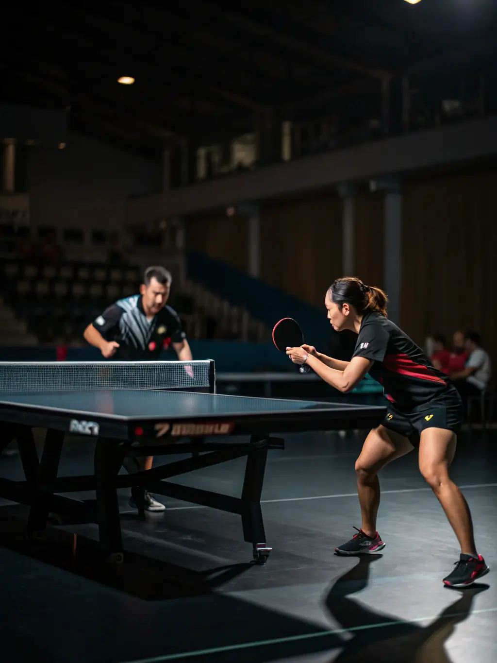 A competitive table tennis match in progress at UNION ATHLETIQUE LA ROCHEFOUCAULD TENNIS DE TABLE, showcasing intense focus and skill.
